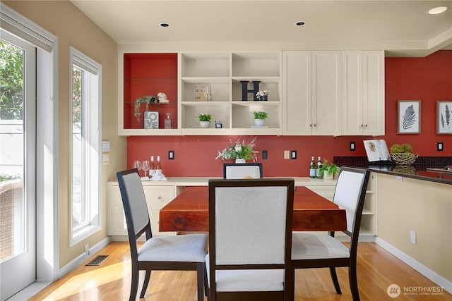 dining space with a wealth of natural light, visible vents, light wood-type flooring, and recessed lighting