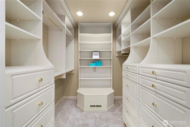 walk in closet featuring light colored carpet