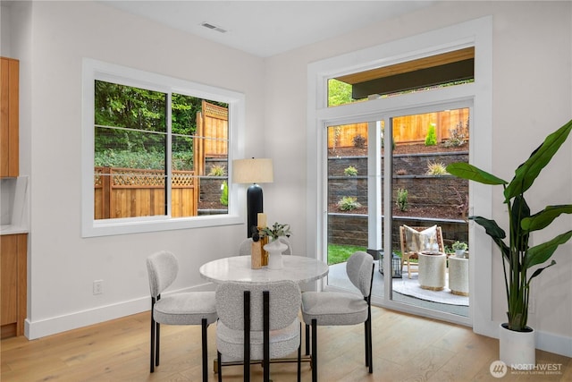 dining area featuring visible vents, baseboards, and light wood-style floors