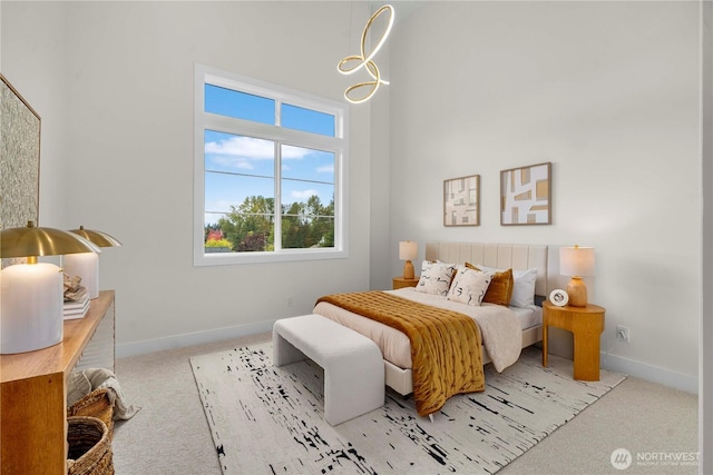 bedroom with baseboards, carpet, and a towering ceiling