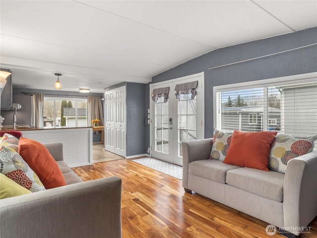 living area with lofted ceiling, french doors, and wood finished floors