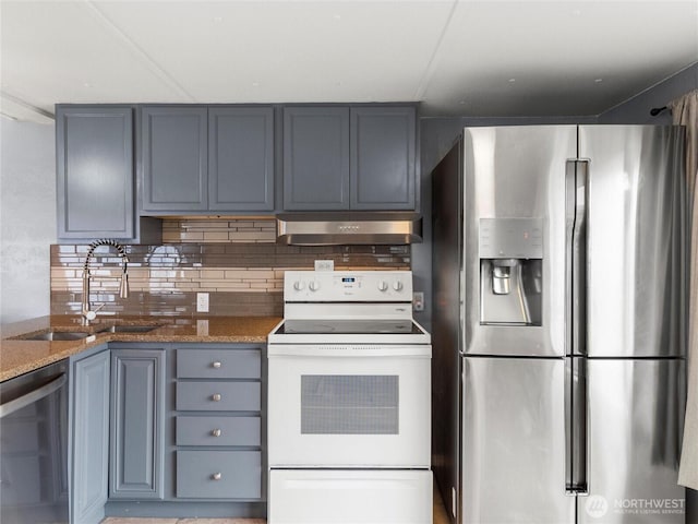 kitchen featuring stone counters, backsplash, appliances with stainless steel finishes, a sink, and under cabinet range hood