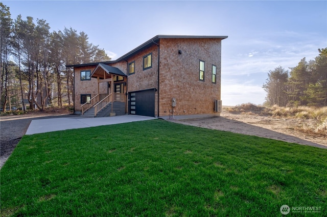 back of house featuring driveway, central AC unit, a lawn, and an attached garage