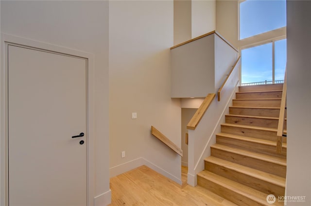 stairway featuring wood finished floors and baseboards