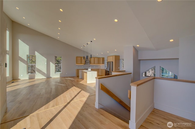 interior space featuring light wood-style floors, freestanding refrigerator, open floor plan, and recessed lighting