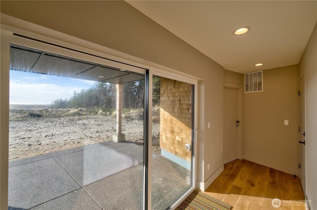 doorway with recessed lighting, wood finished floors, visible vents, and baseboards