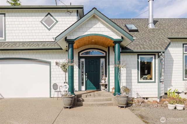 entrance to property with roof with shingles, driveway, and an attached garage