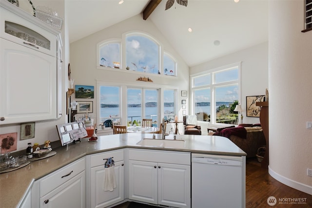 kitchen with a peninsula, dark wood-style flooring, a sink, beam ceiling, and dishwasher