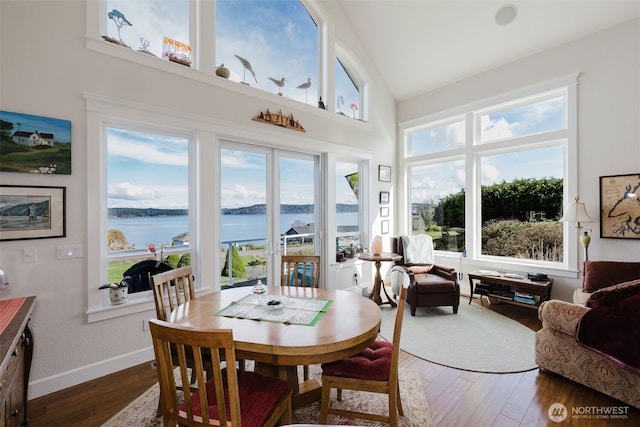 sunroom / solarium with lofted ceiling and a water view