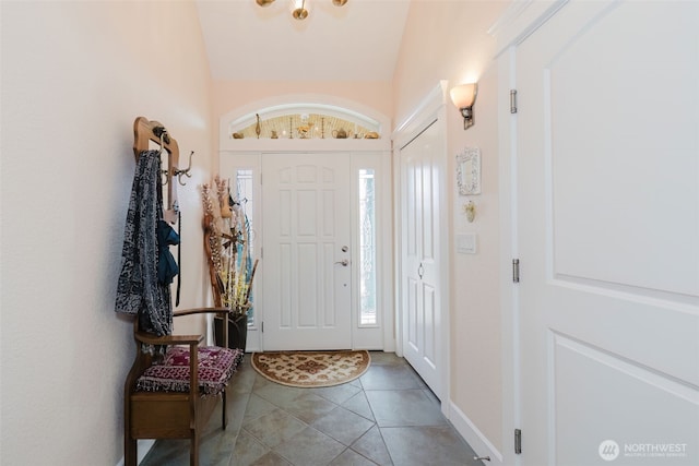 foyer entrance featuring vaulted ceiling and tile patterned floors