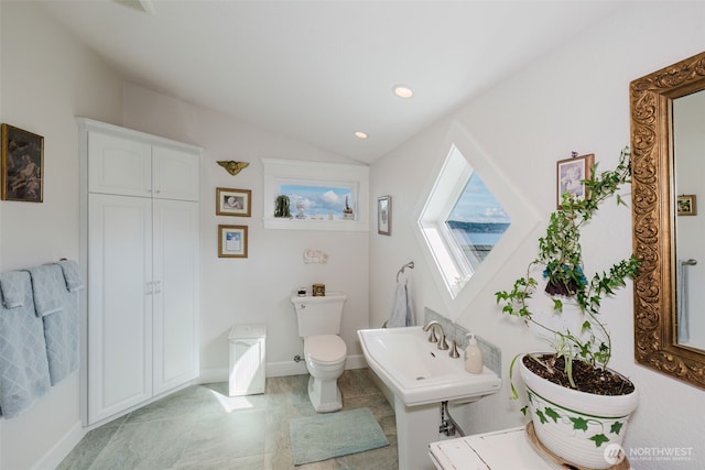 bathroom featuring baseboards, toilet, lofted ceiling, a sink, and recessed lighting