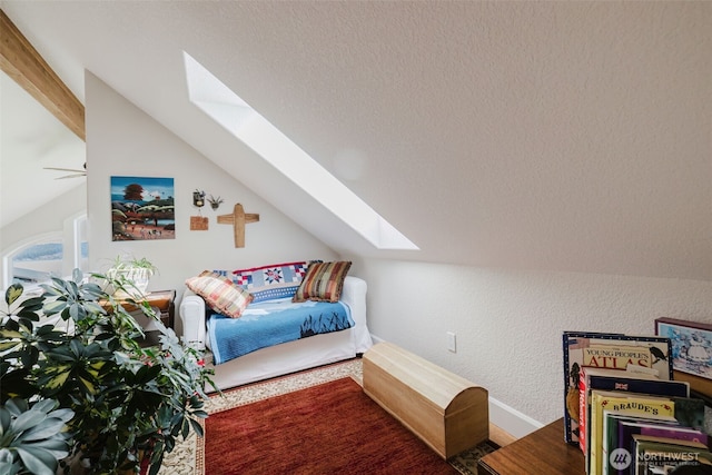 bedroom featuring lofted ceiling with skylight, a textured ceiling, and a textured wall