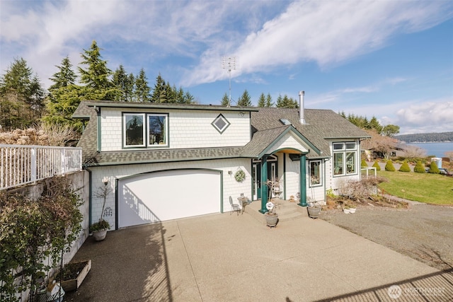 view of front of home with a garage, concrete driveway, and roof with shingles