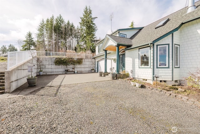 exterior space with gravel driveway and a patio area