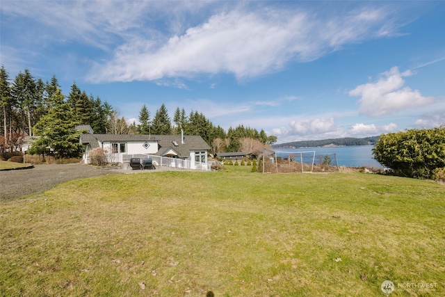 view of yard with a deck with water view