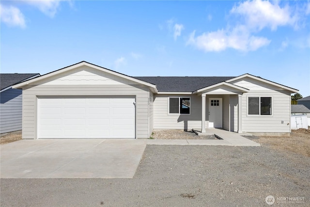 ranch-style house featuring a garage, concrete driveway, and roof with shingles