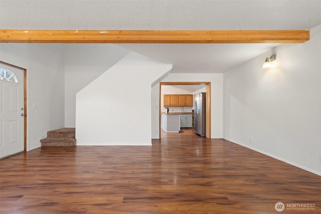 unfurnished living room with vaulted ceiling with beams, dark wood-style floors, and stairway