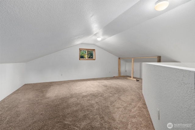 bonus room with carpet, vaulted ceiling, and a textured ceiling