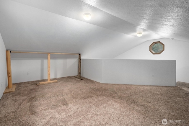 bonus room with carpet, vaulted ceiling, and a textured ceiling