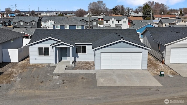 view of front of property with a garage, driveway, fence, and a residential view