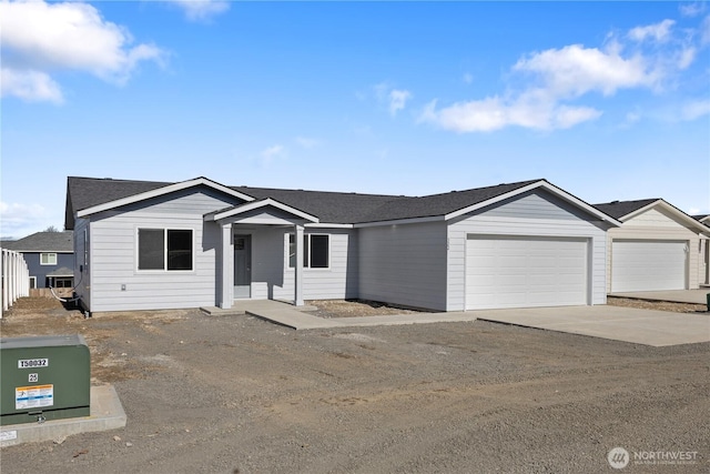 single story home with a shingled roof, driveway, and an attached garage