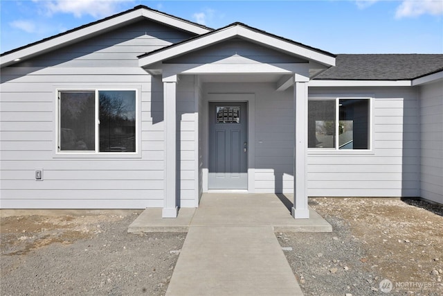 entrance to property with a shingled roof