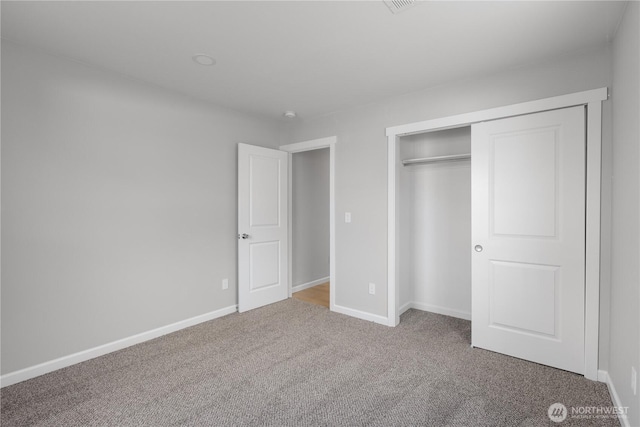 unfurnished bedroom featuring carpet, a closet, and baseboards