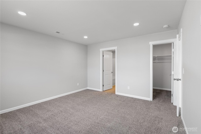 unfurnished bedroom featuring a spacious closet, carpet, visible vents, and recessed lighting