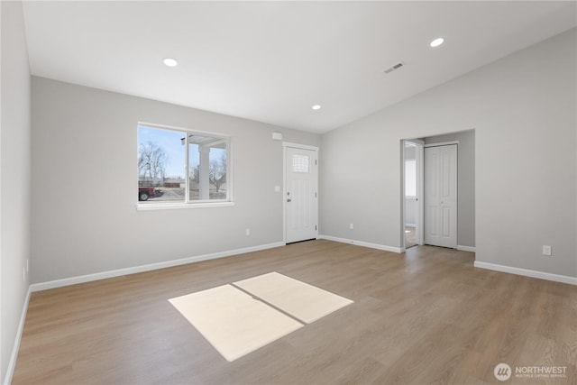 empty room with lofted ceiling, recessed lighting, visible vents, light wood-style flooring, and baseboards