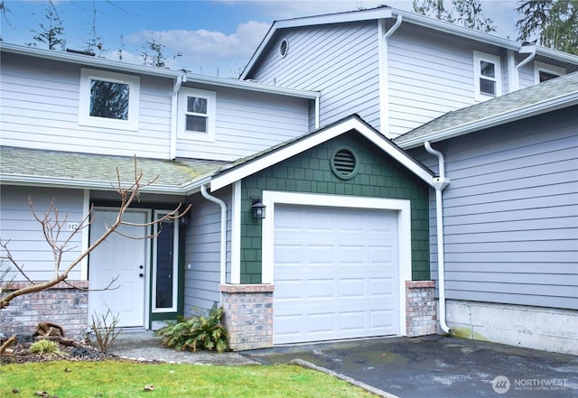 exterior space featuring aphalt driveway and a shingled roof