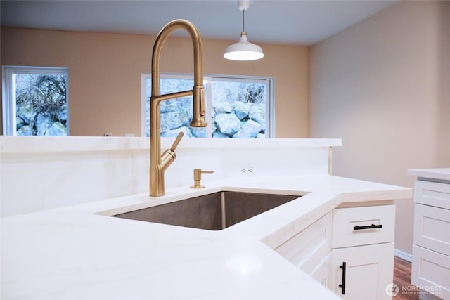 kitchen featuring a sink, plenty of natural light, white cabinets, and light countertops