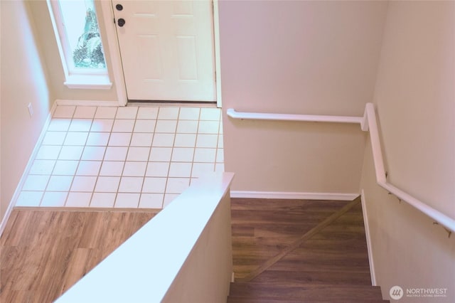 interior space featuring a skylight, baseboards, and wood finished floors