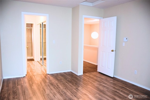 spare room featuring baseboards and wood finished floors