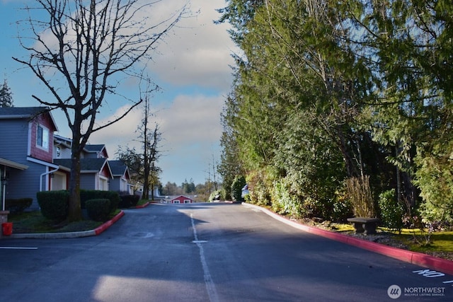 view of road with a residential view and curbs