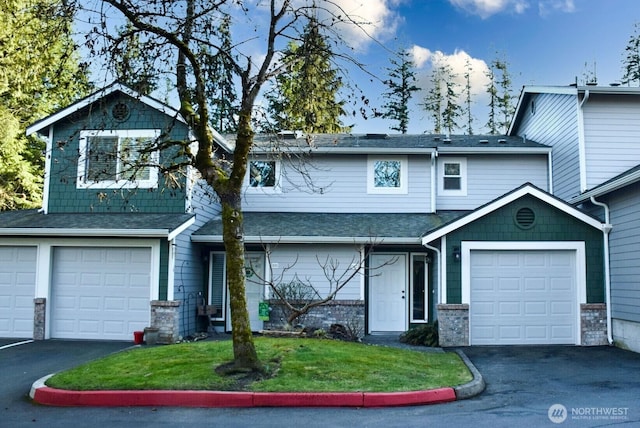 view of front of home with a front lawn, a garage, driveway, and roof with shingles