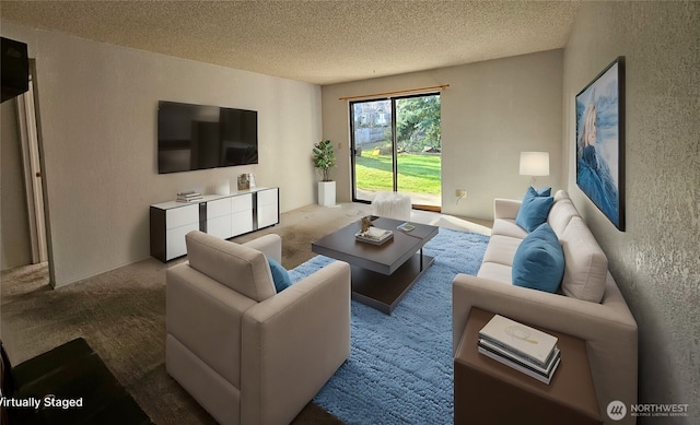 carpeted living area featuring a textured wall and a textured ceiling