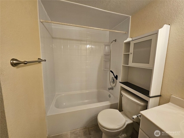 bathroom with toilet,  shower combination, a textured ceiling, and a textured wall