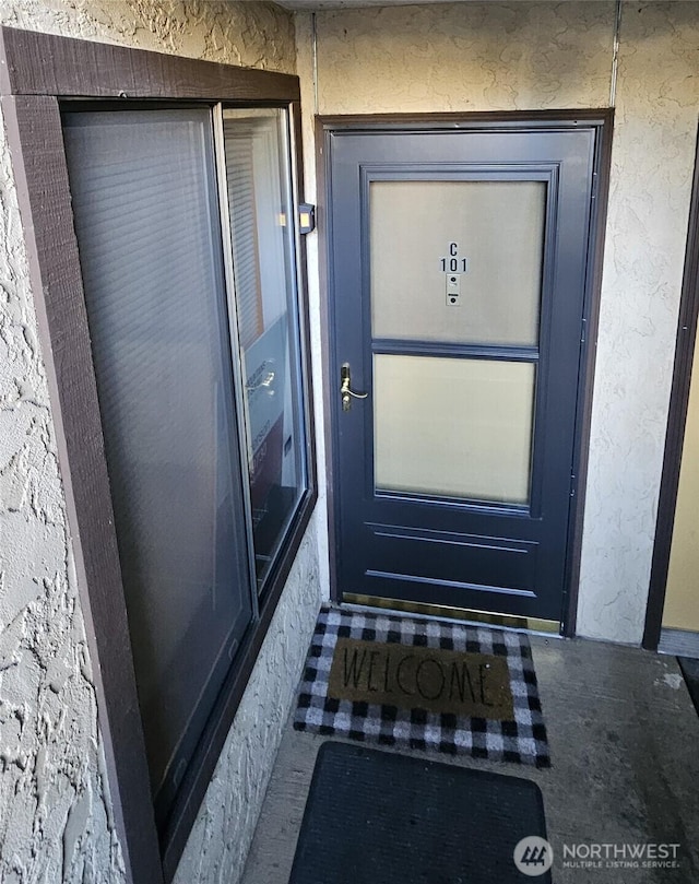 view of exterior entry featuring stucco siding