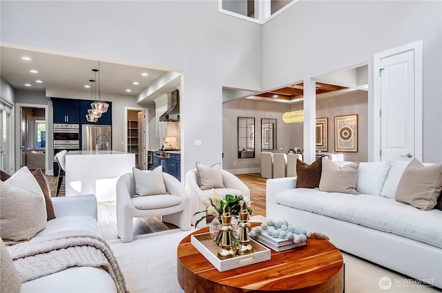 living room with baseboards, a towering ceiling, and recessed lighting