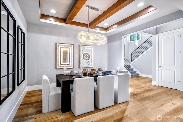 dining room with beam ceiling, baseboards, stairway, and hardwood / wood-style floors