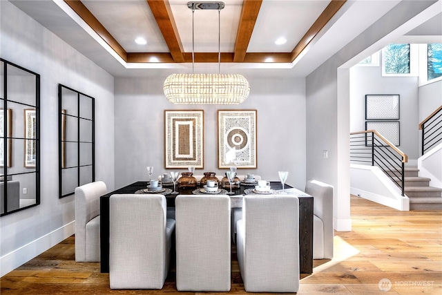 dining area featuring stairway, hardwood / wood-style floors, a chandelier, coffered ceiling, and baseboards