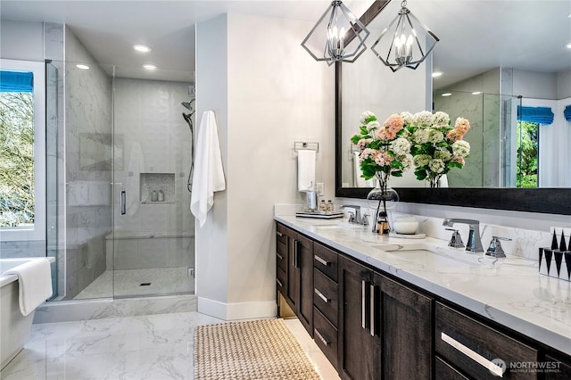 full bath with a stall shower, a sink, and double vanity