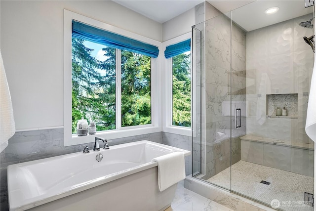 full bath with marble finish floor, a stall shower, a freestanding tub, and recessed lighting