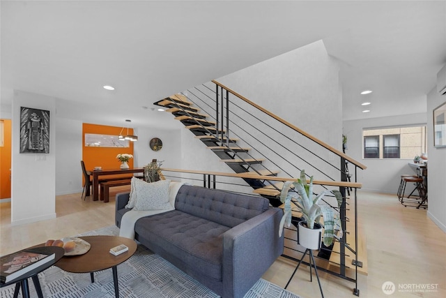 living room featuring recessed lighting, stairs, baseboards, and wood finished floors