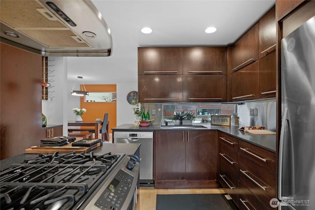 kitchen featuring a sink, dark countertops, dark brown cabinetry, and stainless steel appliances