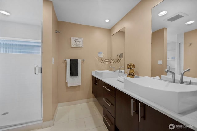 bathroom featuring a sink, visible vents, a stall shower, and tile patterned floors