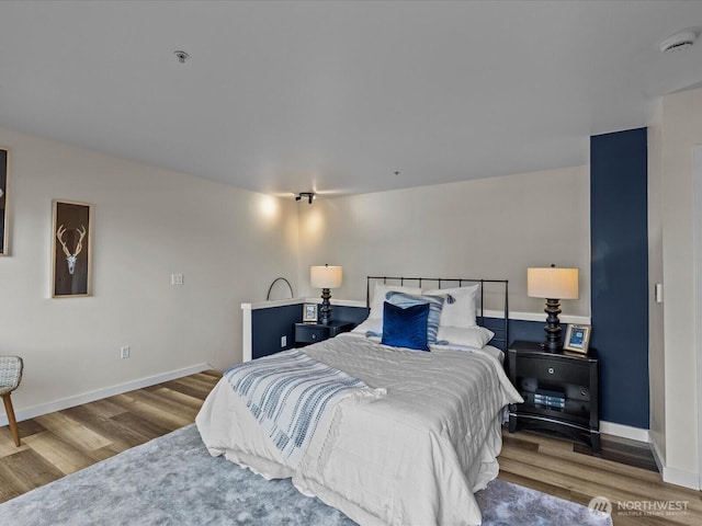 bedroom featuring wood finished floors and baseboards