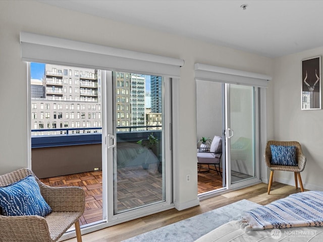 bedroom with access to outside, baseboards, and wood finished floors