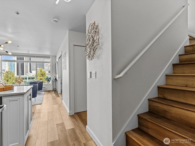 stairway with wood finished floors and baseboards