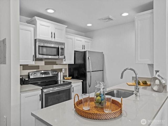 kitchen featuring visible vents, white cabinets, appliances with stainless steel finishes, a sink, and recessed lighting